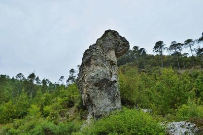 Low angle view of rocks on mountain against sky