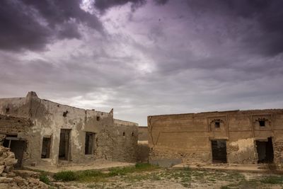 Low angle view of old ruin against cloudy sky