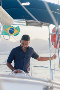 Portrait of young man driving boat in river