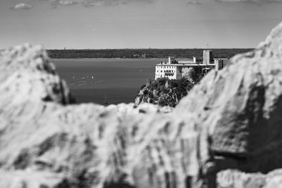 Scenic view of sea by buildings against sky