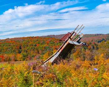 Abandoned traditional windmill on field against sky during autumn