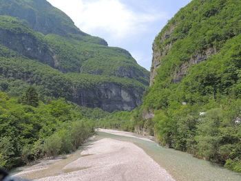 Road amidst green mountains against sky