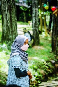 Rear view of woman standing in forest