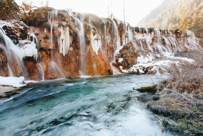 Waterfall along rocks in sea