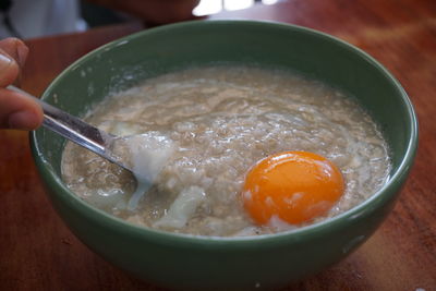 Close-up of hand holding soup in bowl