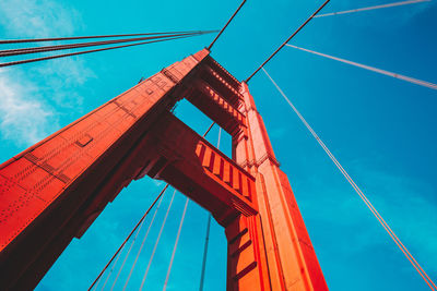 Low angle view of suspension bridge against blue sky