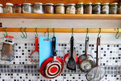 Close-up of various bottles on shelf against wall