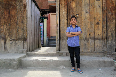 Portrait of a boy against wooden wall