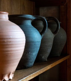 Close-up of handmade pottery in cabinet