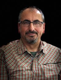 Portrait of man wearing eyeglasses against black background