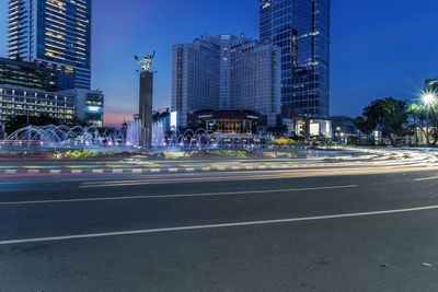 Blurred motion of city street and modern buildings against sky