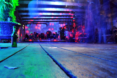 Beer bottle on wooden floor at nightclub