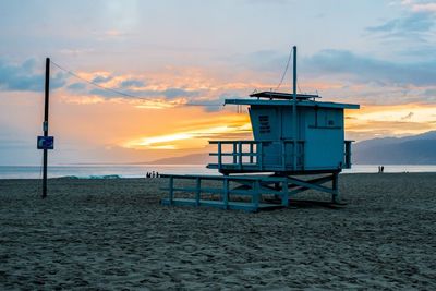 Lifeguard hut at beach during sunset