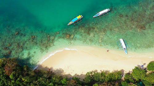 Beach and turquoise water of the lagoon with tourists and boats. marcos island, hundred islands 