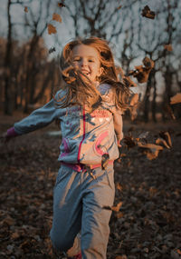 Full length of a smiling girl on field during autumn