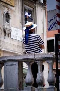 Rear view of man standing in front of building