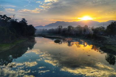 Scenic view of lake against sky at sunset