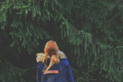 Rear view of woman standing in forest