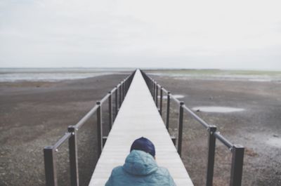 Rear view of person on beach against sky