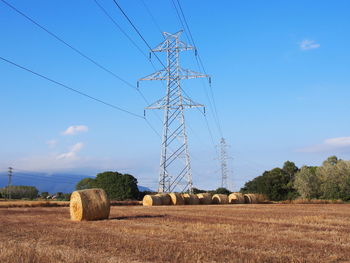 Hay bales on field against sky