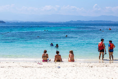 People at beach against sky