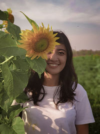 Portrait of smiling woman with red flower