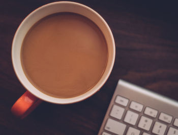 Overhead view of cup of tea next to keypad