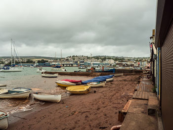 Boats moored at harbor against sky