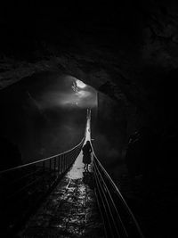 Rear view of woman standing on bridge against tunnel