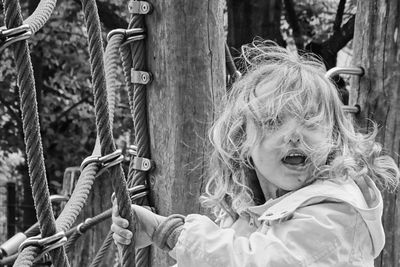 Portrait of girl against tree trunk