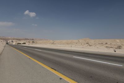 Scenic view of desert road against sky