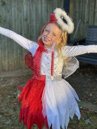 Portrait of young woman standing outside in halloween costume of half angel half devil 