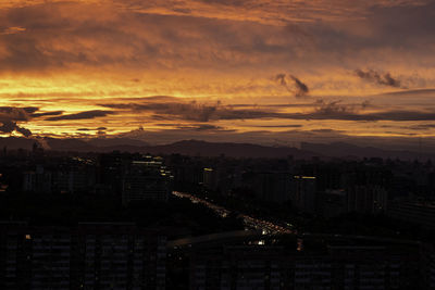 High angle view of illuminated buildings at sunset