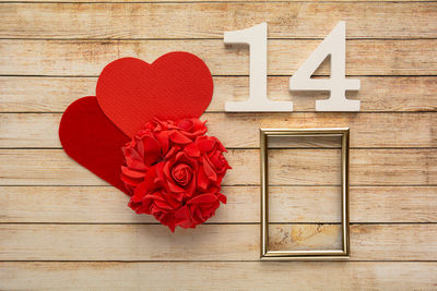 Close-up of red rose on wooden table