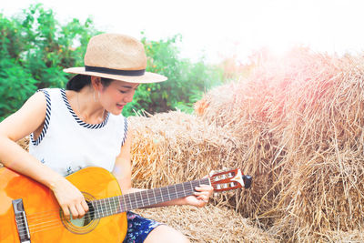 Woman playing guitar in park