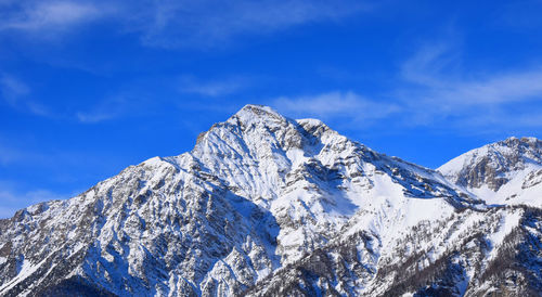 Scenic view of snowcapped mountains against blue sky