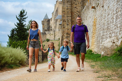 Rear view of family walking on field