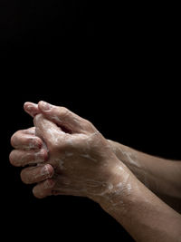 Close-up of hand over black background