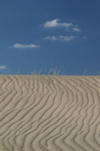 Sand dune on beach against sky