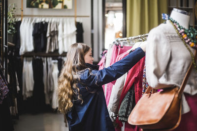 Side view of girl shopping in clothing store