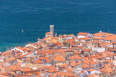 High angle view of cityscape by sea against sky