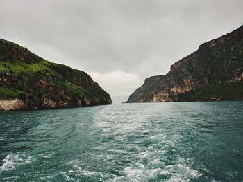 Scenic view of sea and mountains against sky