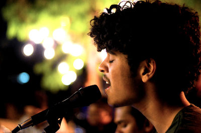 Close-up of young man singing at concert