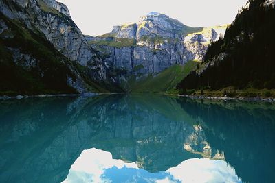 Scenic view of lake by mountain against sky