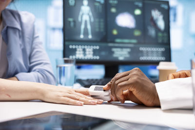 Midsection of woman using mobile phone on table