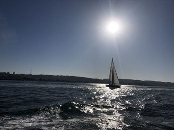 Sailboat sailing on sea against clear sky