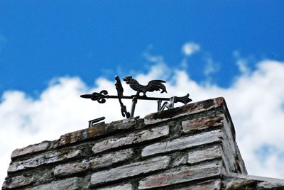 Low angle view of birds perching on roof