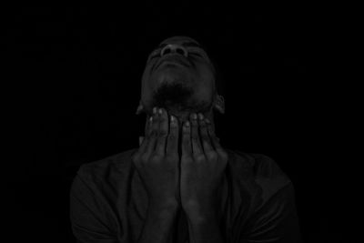 Portrait of man against black background