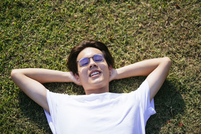 Young woman wearing sunglasses lying on grass