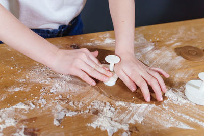 A little girl makes heart-shaped cookies from rye dough. the concept of valentine's day 